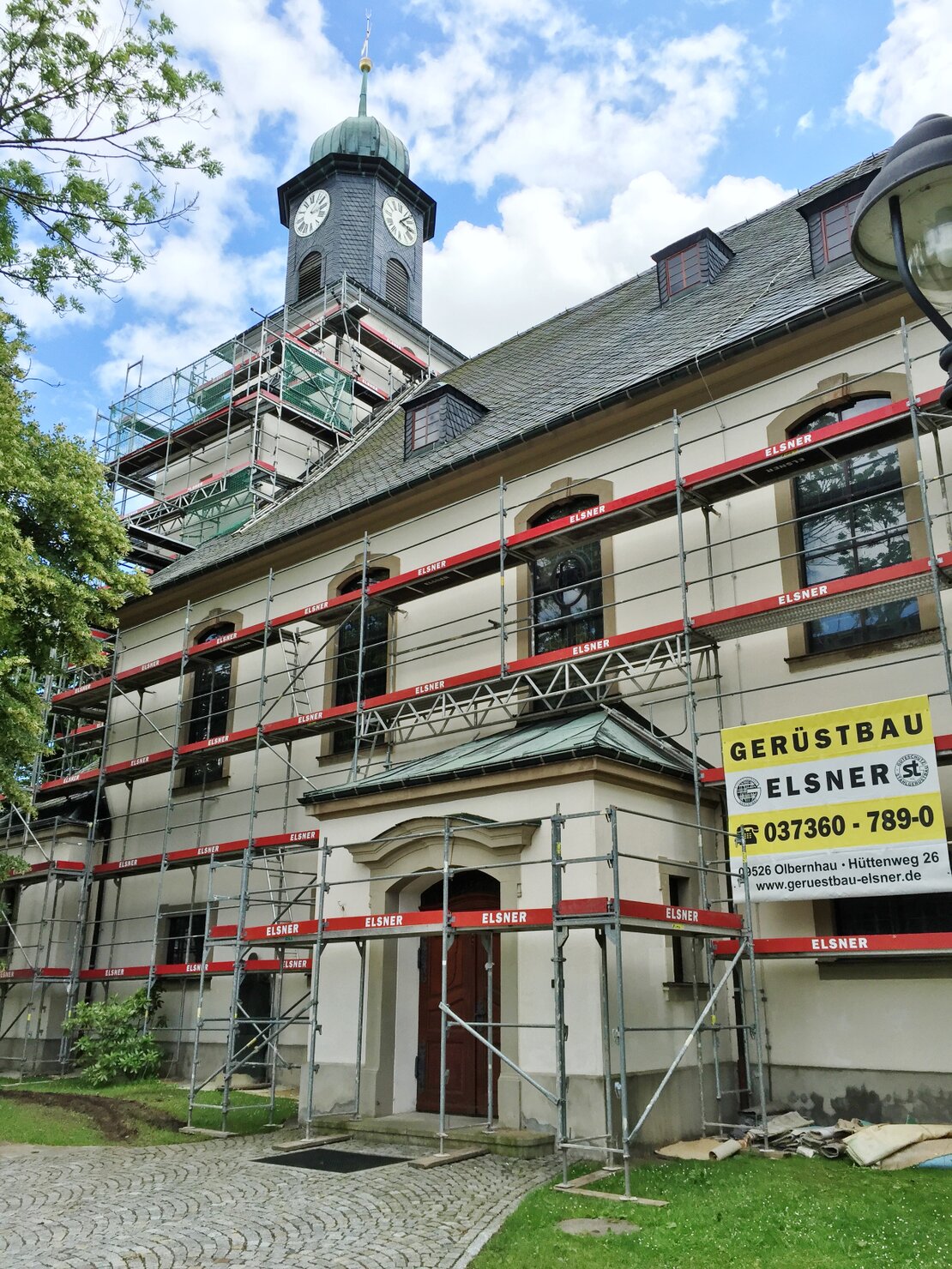 Gerüst an einem Kirchturm und einer historischen Fassade